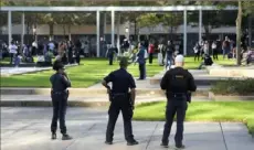  ?? Karen Warren/Houston Chronicle via AP ?? Houston police officers watch over displaced churchgoer­s outside Lakewood Church on Sunday after a shooting during a Spanish church service.