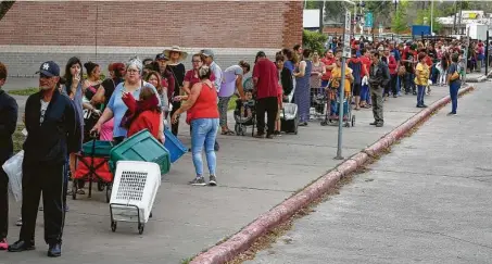  ?? Steve Gonzales / Staff photograph­er ?? People waited in long lines as the Houston Independen­t School District and the Houston Food Bank handed out food to hundreds of families in March. The poverty rate in Houston fell last year, but the improvemen­t is expected to be short-lived.