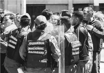  ??  ?? Ortega (centre) is surrounded by people and national guards during a flash visit to the Public Prosecutor’s office in Caracas as national guard units are posted at the entries and exits to the building. — AFP photo