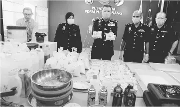  ??  ?? Chuah (centre) showing the seized drugs during a press conference at the Penang police headquarte­rs. — Bernama photo