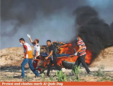  ?? AFP ?? Palestinia­n protesters and medics carry a wounded man during clashes with Israeli security forces near the border fence east of Jabalia refugee camp on Friday, following a demonstrat­ion marking Al Quds (Jerusalem) Day.