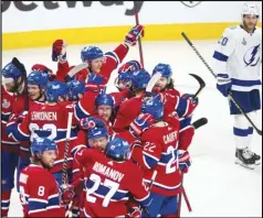  ?? The Canadian Press via AP ?? EXTRA WIN — Tampa Bay Lightning’s Blake Coleman (20) looks on as Montreal Canadiens celebrate teammate Josh Anderson’s (17) winning goal at the end of overtime of Game 4 of the NHL hockey Stanley Cup final in Montreal on Monday.