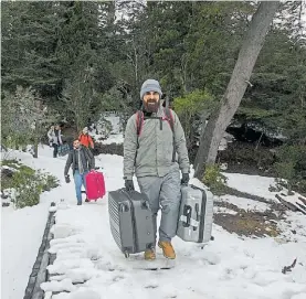  ??  ?? Viaje atípico. Los turistas deben caminar con sus valijas por la nieve.
