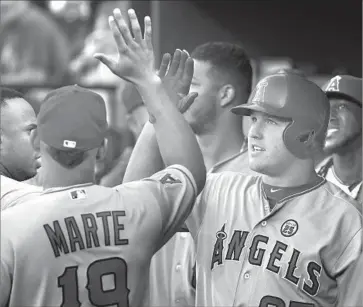  ?? Patrick Semansky Associated Press ?? THE ANGELS got rolling early when Mike Trout, the second batter of the game, homered in the first inning, earning a high-five from Jefry Marte. Trout homered again in the third against Baltimore’s Kevin Gausman.