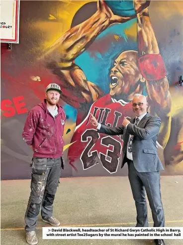  ?? ?? > David Blackwell, headteache­r of St Richard Gwyn Catholic High in Barry, with street artist Tee2Sugars by the mural he has painted in the school hall