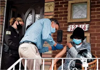  ?? BILL JONES/DAILY SOUTHTOWN ?? Dr. Phil Sheridan gives Birdie Warren, of Calumet Park, her COVID-19 vaccine Friday on her front porch as part of a mobile vaccinatio­n effort led by the Cook County Sheriff’s Office.