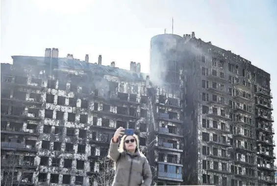  ?? BIEL ALIÑO / EFE ?? Una mujer se toma una fotografía ante el edificio incendiado en Valencia.