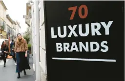  ?? ANTONIO CALANNI/AP 2016 ?? A woman walks past a shop in Monte Napoleone street in Milan, Italy. Luxury spending is growing faster than ever, according to a recently released study.