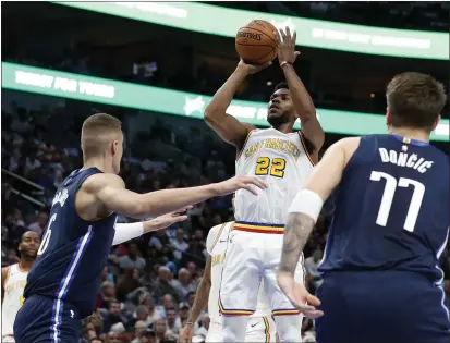  ?? TONY GUTIERREZ — THE ASSOCIATED PRESS ?? Mavericks forward Kristaps Porzingis (6) and forward Luka Doncic (77) defend as Warriors forward Glenn Robinson III (22) attempts a shot in the first half Wednesday in Dallas.