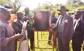  ??  ?? Chivi Rural District Council chairperso­n Cllr Killer Zivhu (in green T-shirt and scarf) hands over drip irrigation equipment for schools to chiefs and headmen in Chivi South recently