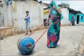  ?? MUJEEB FARUQUI/HT ?? A woman uses a ‘Water Wheel’ — a drum that doubles up as a wheel, attached to two handles— to take water to her home in Patharihav­eli village of Madhya Pradesh’s Vidisha district.