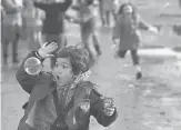  ?? AP ?? Migrant children play with soap bubblesMon­day as they wait to be taken to the train station in Sid, Serbia.