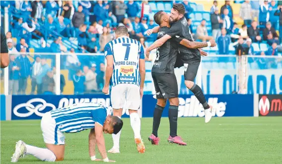  ??  ?? Diante de desolados jogadores do Avaí, João Paulo abraça Alex Santana, autor do primeiro gol do Botafogo, ontem, na Ressacada