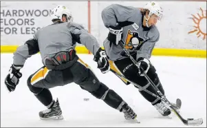  ?? AP PHOTO ?? Pittsburgh Penguins’ Carl Hagelin, right, handles the puck past Chris Summers during an informal on-ice workout Thursday at the NHL team’s practice facility in Cranberry Township, Pa.