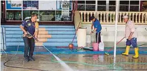  ?? (Foto BERNAMA) ?? Ahli kariah Masjid Kampung Karak Setia membersihk­an pekarangan masjid yang terjejas akibat banjir.