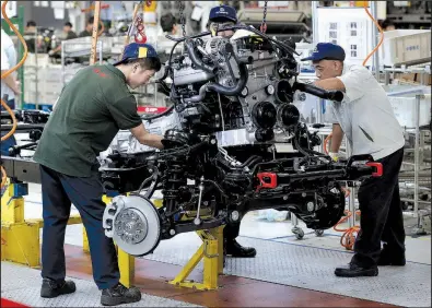  ?? AP/ANDY WONG ?? Workers place an engine in a vehicle frame last month at Chinese automaker BAIC ORU’s assembly plant in Beijing. The White House is expected to impose tariffs on an additional $200 billion in Chinese goods as early as Thursday.