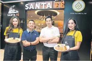  ??  ?? Mr Piti, second right, and Surachai Chananudej, chief executive of KT Restaurant Co, second left display some menu items from Santa Fe eatery.