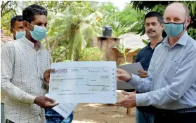  ??  ?? IWMI’s SImon Langan hands over a cheque to a farmer while Dr. Giriraj Amarnath looks on