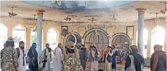  ?? | AFP ?? TALIBAN members and officials investigat­e the bombing of the Shia mosque in Kunduz at the weekend.