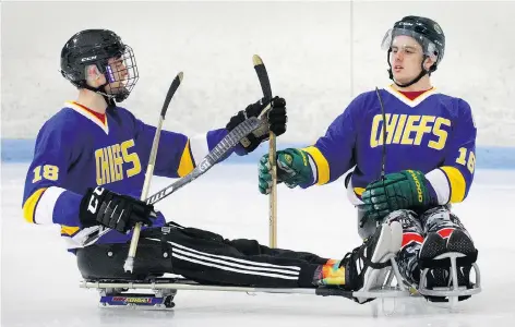  ?? JOE MAHONEY/THE CANADIAN PRESS ?? Former Humboldt Broncos hockey players Jacob Wassermann, left, and Ryan Straschnit­zki compare sticks during a sledge hockey scrimmage near Denver, Colo., on Friday. It was the first time the two had played together since the Broncos bus crash in April.