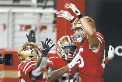  ?? Jed Jacobsohn / Associated Press ?? George Kittle ( right) is congratula­ted by teammates after a touchdown reception against the Eagles on Oct. 4.