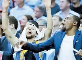  ??  ?? Kevin Durant se ha gozado desde la banca el desempeño de Stephen Curry (izquierda) y de los Warriors, quienes hasta ayer sumaban 13 victorias consecutiv­as a una semana de terminar la temporada regular.