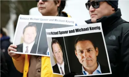  ??  ?? People hold signs calling for China to release Michael Kovrig and Michael Spavor in Vancouver, British Columbia, on 6 March 2019. Photograph: Lindsey Wasson/Reuters