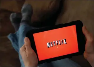  ?? The Associated Press ?? STREAMING FRENZY: A person displays Netflix on a tablet in North Andover, Mass., on Jan. 17, 2014. The future of TV may well be a mishmash of streaming services that could wind up costing pretty close to a $100 cable bundle, but that are way too...