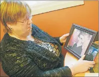  ?? MITCH MACDONALD/TC MEDIA ?? Stratford resident Frances Lamoureux looks over some pictures of herself with her sisters after spending years trying to re-connect with her many siblings. Having grown up in foster care, Lamoureux has since met with or spoken to 11 of her 13 siblings...