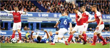  ??  ?? Everton’s Phil Jagielka (centre) scores their first goal during the English Premier League football match between Everton and Arsenal at Goodison Park in Liverpool, north west England. — Reuters photo