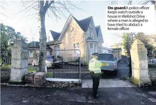  ??  ?? On guard A police officer keeps watch outside a house in Wellshot Drive where a man is alleged to have tried to abduct a female officer