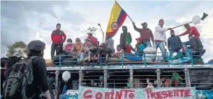  ?? AFP ?? Colombian indigenous people flutter a Colombian flag as they arrive in Bogota on a ‘chiva’ — a local transport vehicle — on Sunday to demand a meeting with President Ivan Duque.