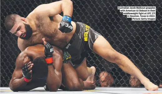  ?? ?? Australian Jacob Malkoun grapples with American AJ Dobson in their middleweig­ht fight at UFC 271 in Houston, Texas in 2022. Picture: Getty Images