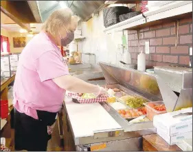  ??  ?? Jennifer Bramwell of Summers grills hamburgers at Burgerland in Lincoln. Burgerland is open with full capacity for inside dining. (NWA Democrat-Gazette/Lynn Kutter)