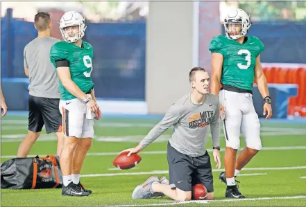  ?? THE OKLAHOMAN] ?? Oklahoma State's Dru Brown, left, and Spencer Sanders line up behind offensive coordinato­r and quarterbac­ks coach Sean Gleeson during Tuesday's practice. Head coach Mike Gundy may start the season playing both quarterbac­ks as no clear starter has emerged. [BRYAN TERRY/