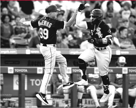  ?? JAE C. HONG/AP ?? The White Sox’ Josh Harrison celebrates his home run in the fifth inning Tuesday against the Angels with third-base coach Joe McEwing.