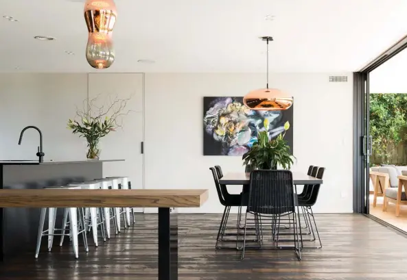  ??  ?? OPPOSITE & ABOVE Miller, Rebecca, Paul and Isabella enjoy a snack in the kitchen designed by Colleen Holder Design. “I’ve always wanted to do a black kitchen – I like the glamour and drama of such a dark palette,” says Rebecca. “Our brief was to have a...