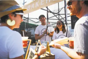  ?? Gabrielle Lurie / Special to The Chronicle ?? Owner Nick Lee (center, left) and Christy Acuna (center, right) share a laugh with customers at the Sage Bakehouse pie stand at the Clement Street Farmers’ Market.