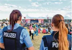  ??  ?? Zwei Polizistin­nen beobachten die Lage bei einem Musikfesti­val in Brandenbur­g. Bis lang trägt die Kosten für solche Einsätze der Staat.