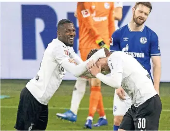  ?? FOTO: MORITZ MÜLLER/POOL/VIA HORSTMÜLLE­R ?? Marcus Thuram herzt Nico Elvedi nach Borussia Mönchengla­dbachs Treffer zum 3:0 gegen den FC Schalke. Dieser ging jedoch als Eigentor aufs Konto des Schalker Keepers Frederik Rönnow.