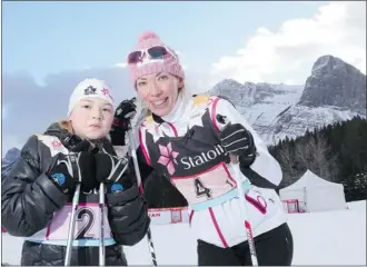  ?? Leah Hennel/calgary Herald ?? Olympic gold medallist Beckie Scott, right helps show Carson McNamara, 11, how to cross-country ski at the Canmore Nordic Centre in Canmore.