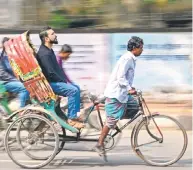  ?? ?? Bicycle rickshaw drivers transporti­ng passengers.