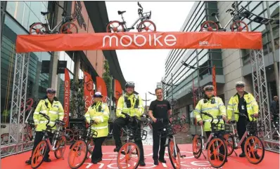  ?? XINHUA ?? Manchester traffic police pose with Mobike bicycles at the launch of the bike-sharing services on June 29. Manchester marks the beginning of the Chinese company’s global expansion, which popularize­s the concept of sharing economy.