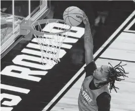  ?? KAITLIN MCKEOWN kmckeown@newsobserv­er.com ?? N.C. State’s Kam Woods dunks the ball during a practice on Wednesday, March 20, 2024, at PPG Paints Arena in Pittsburgh, Pa.