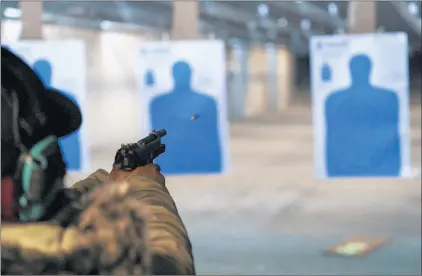  ?? YOUNGRAE KIM/CHICAGO TRIBUNE PHOTOS ?? Ariel Charles fires a pistol during a target practice class at Eagle Sports Range in Oak Forest on Jan. 16.