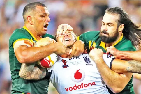  ?? — AFP photo ?? Ashton Sims of Fiji is tackled by Will Chambers (L) and Aaron Woods (R) of Australia during the Rugby League World Cup men’s semi-final match between Australia and Fiji at the Suncorp Stadium in Brisbane on November 24, 2017.