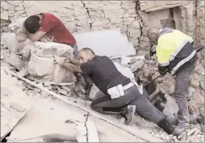  ?? The Associated Press ?? A man cries as another man, who’s injured, gets help in Amatrice, central Italy, following a devastatin­g earthquake on Wednesday.