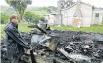  ?? PHOTO: RICHARD DAVISON ?? Reduced to ashes . . . Kaitangata resident Christine Tucker inspects the destructio­n from a shed fire close to her cottage on Sunday night.