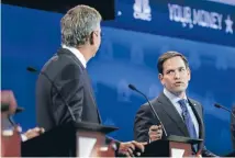  ?? Photo: REUTERS ?? Jeb Bush, left, receives a lesson in politics from rival US Senator Marco Rubio during the Republican presidenti­al candidates debate held by CNBC in Boulder, Colorado.