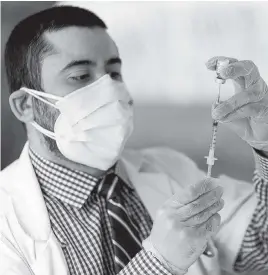  ?? MATIAS J. OCNER mocner@miamiheral­d.com ?? Dr. Daniel Carvajal draws a syringe with the Pfizer-BioNTech COVID-19 vaccine at The Palace Renaissanc­e & Royale, an assisted-living facility in Kendall on Jan. 13.